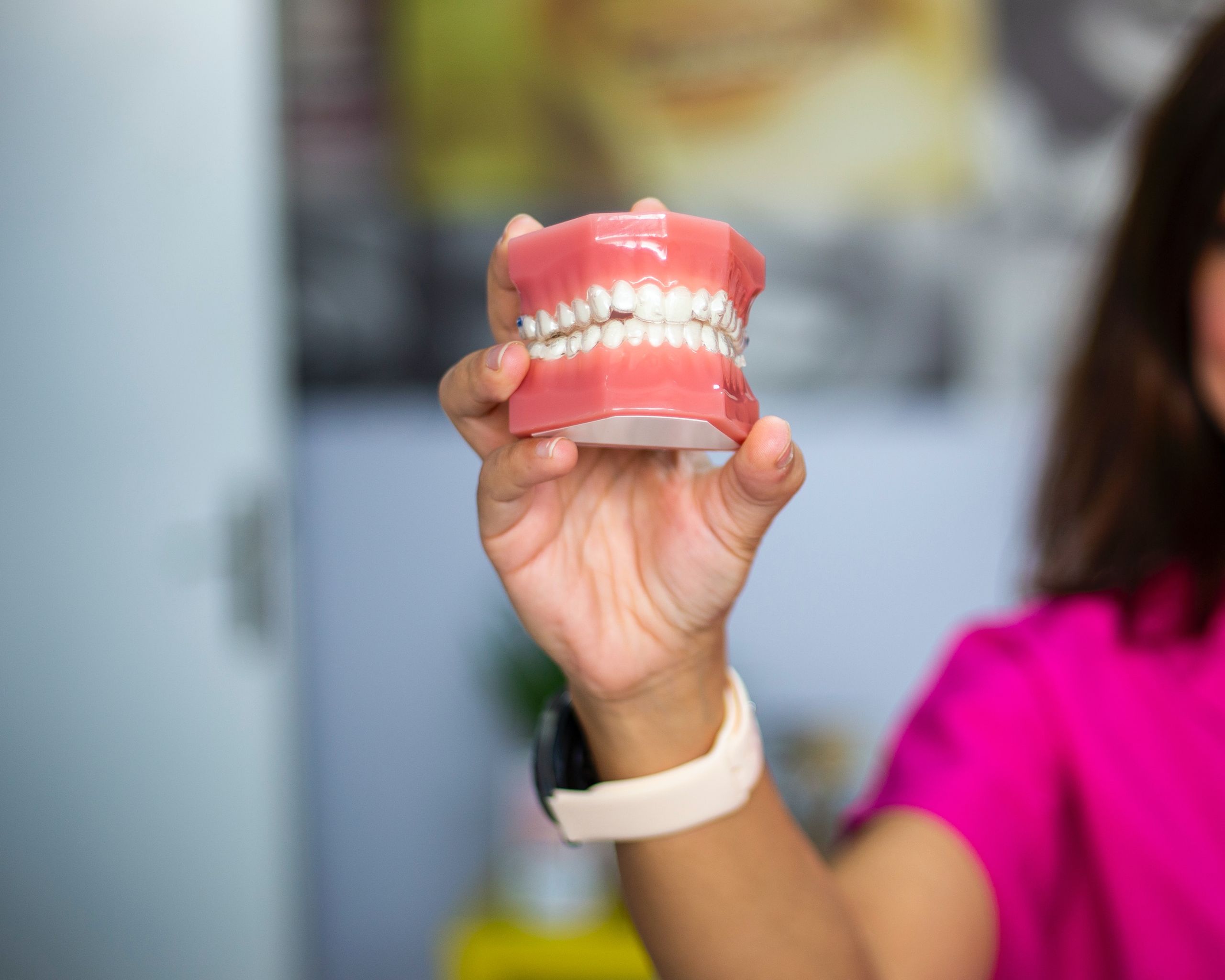 Partial and Complete Dentures 5 A dentist's hand holding a dental teeth model indoors. Ideal for dental care concepts.
