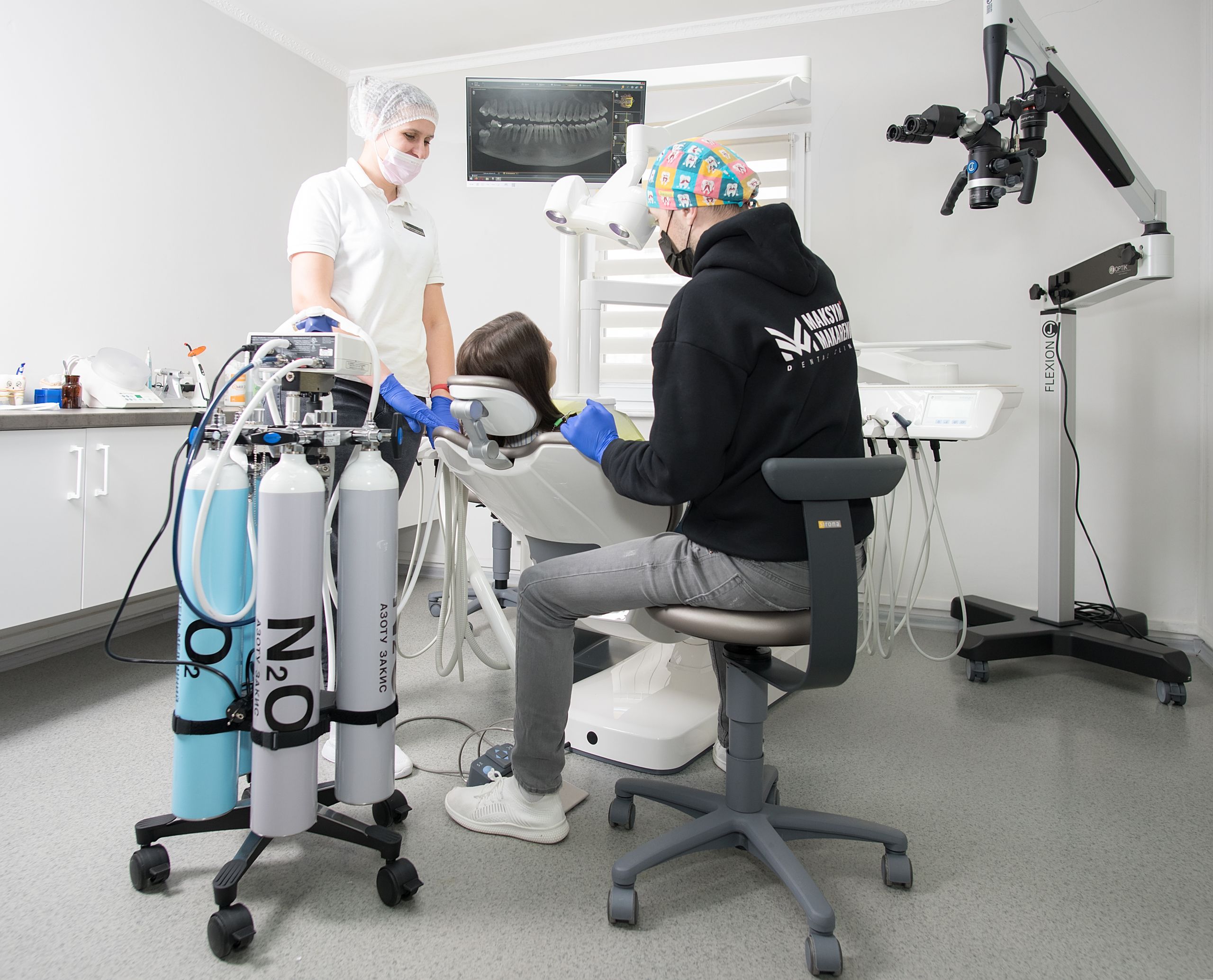 Dentist and assistant performing dental procedure with modern equipment in Kiev clinic.